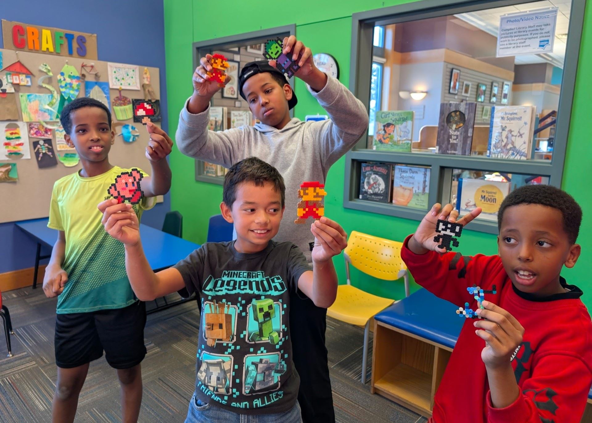 Boys exuberantly show off their perler bead creations